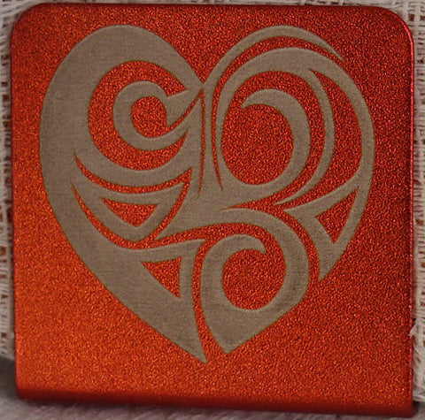 A 1.25" square aluminum hat clip with round corners and  a laser engraved  geometric  tribal heart design